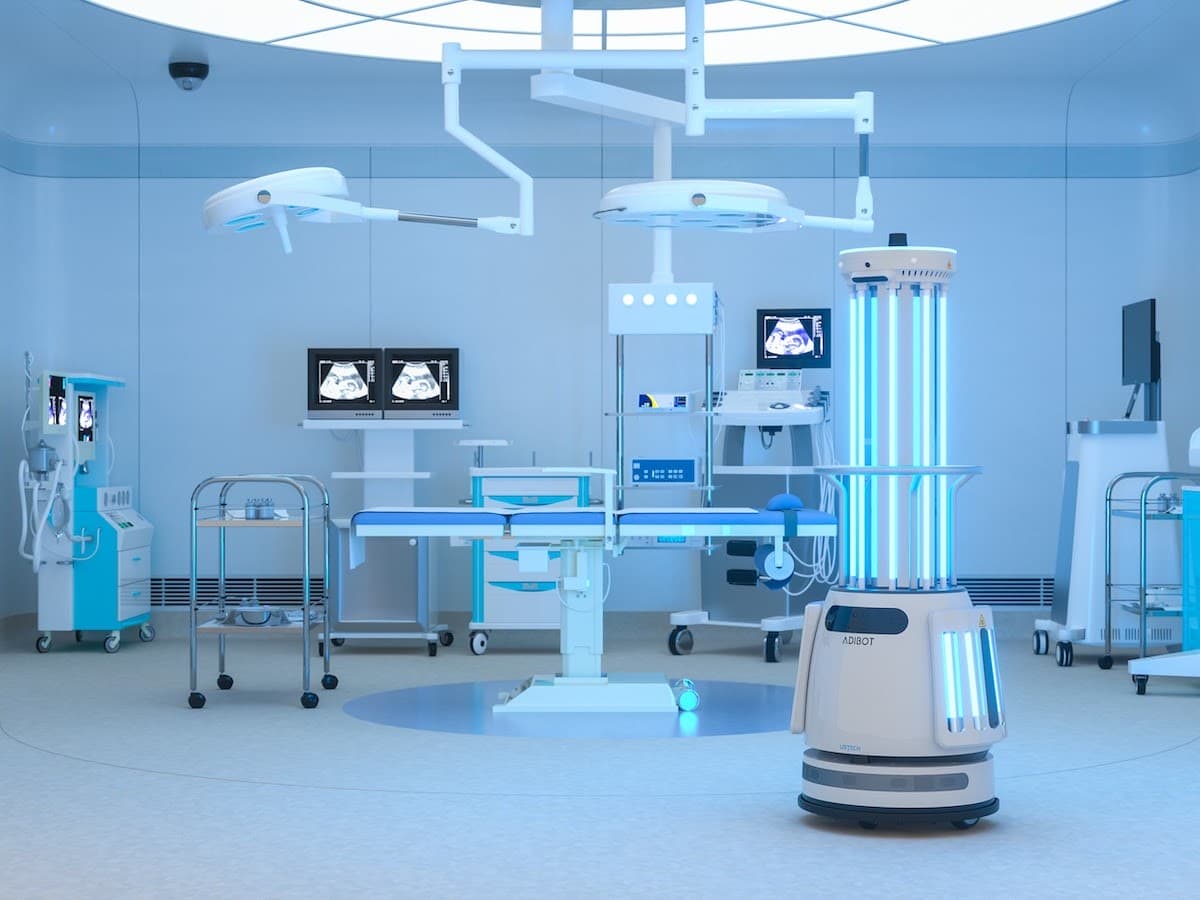 casestudy-adibot A modern, high-tech medical room featuring advanced equipment, robotic devices, and monitors displaying medical images. The room has bright lighting, blue accents, and is organized with various medical supplies and machinery.