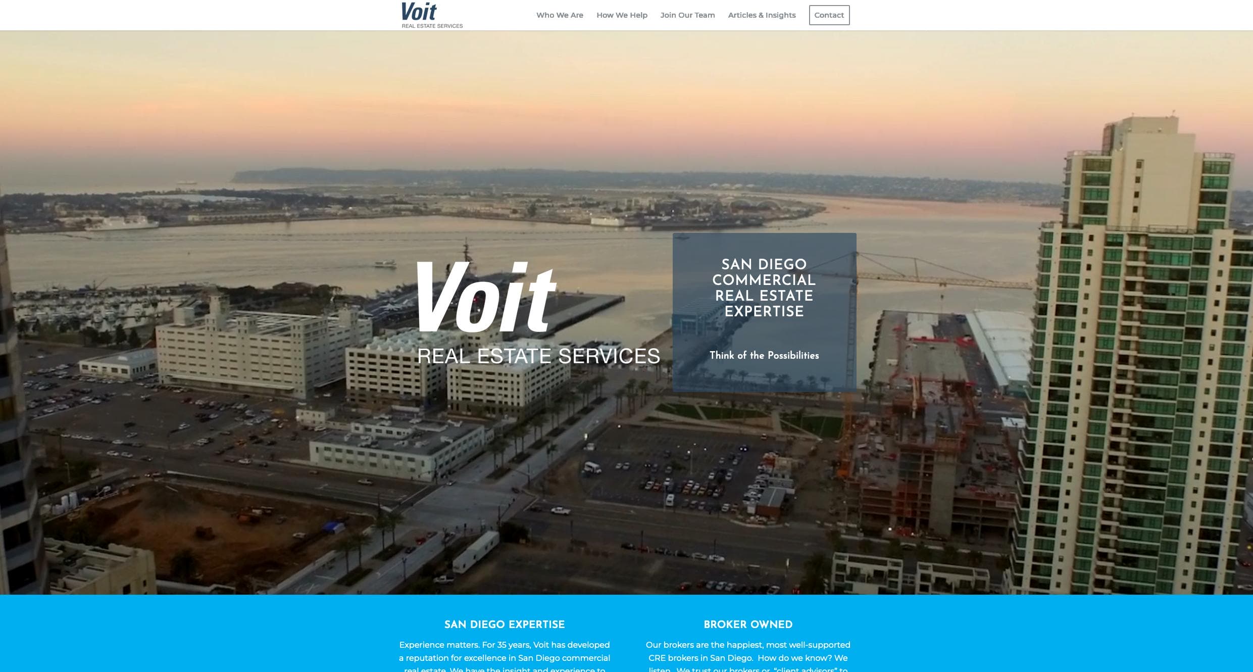 A cityscape view of San Diego with tall buildings and construction near the waterfront at sunset. The ocean is visible in the background. Text on the image reads, "Voit Real Estate Services - San Diego Commercial Real Estate Expertise.
